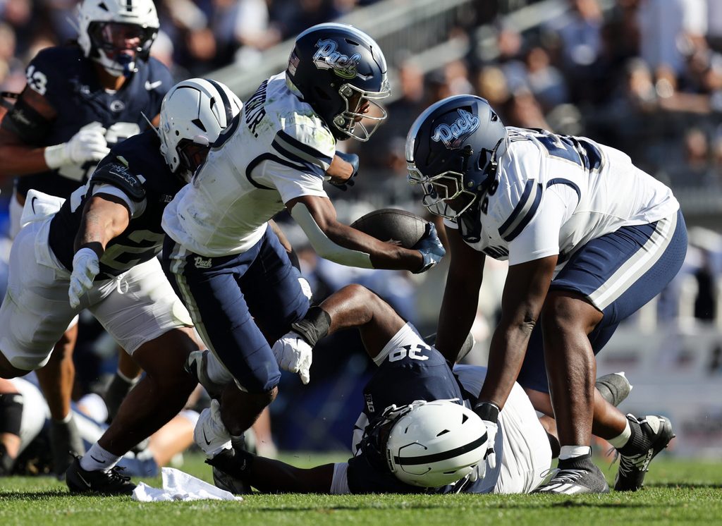 Aug 30, 2025; University Park, Pennsylvania, USA; Nevada Wolf Pack running back Herschel Turner (2) runs with the ball while avoiding a tackle by Penn State Nittany Lions defensive tackle Ty Blanding (39) during the second quarter at Beaver Stadium. Mandatory Credit: Matthew O'Haren-Imagn Images