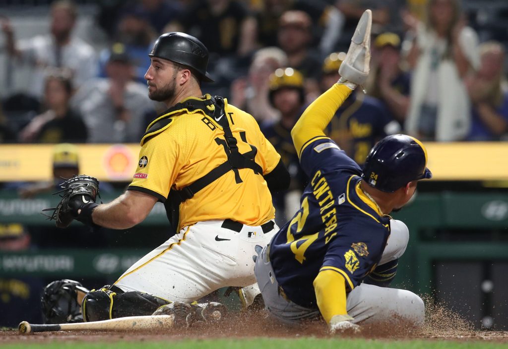 Sep 5, 2025; Pittsburgh, Pennsylvania, USA;  Milwaukee Brewers catcher William Contreras (24) slides behind Pittsburgh Pirates catcher Joey Bart (14) to score a run during the ninth inning at PNC Park. Mandatory Credit: Charles LeClaire-Imagn Images