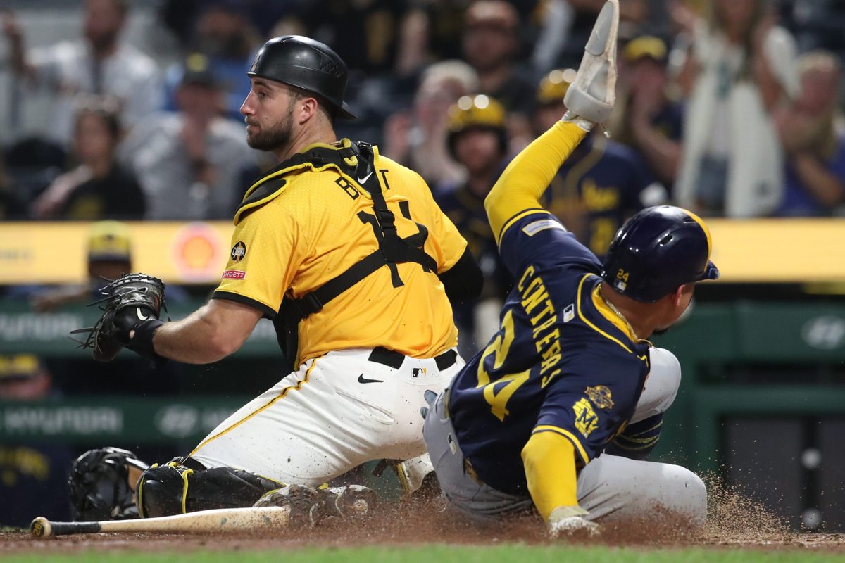 Sep 5, 2025; Pittsburgh, Pennsylvania, USA; Milwaukee Brewers catcher William Contreras (24) slides behind Pittsburgh Pirates catcher Joey Bart (14) to score a run during the ninth inning at PNC Park. Mandatory Credit: Charles LeClaire-Imagn Images