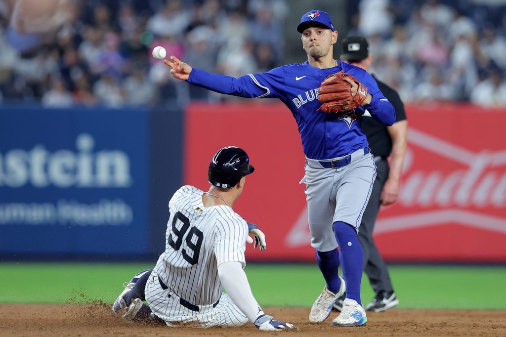 Sep 5, 2025; Bronx, New York, USA; Toronto Blue Jays second baseman Andres Gimenez (0) forces out New York Yankees right fielder Aaron Judge (99) at second base and throws to first to complete a game ending double play on a ball hit by designated hitter Giancarlo Stanton (not pictured) during the ninth inning at Yankee Stadium. Mandatory Credit: Brad Penner-Imagn Images