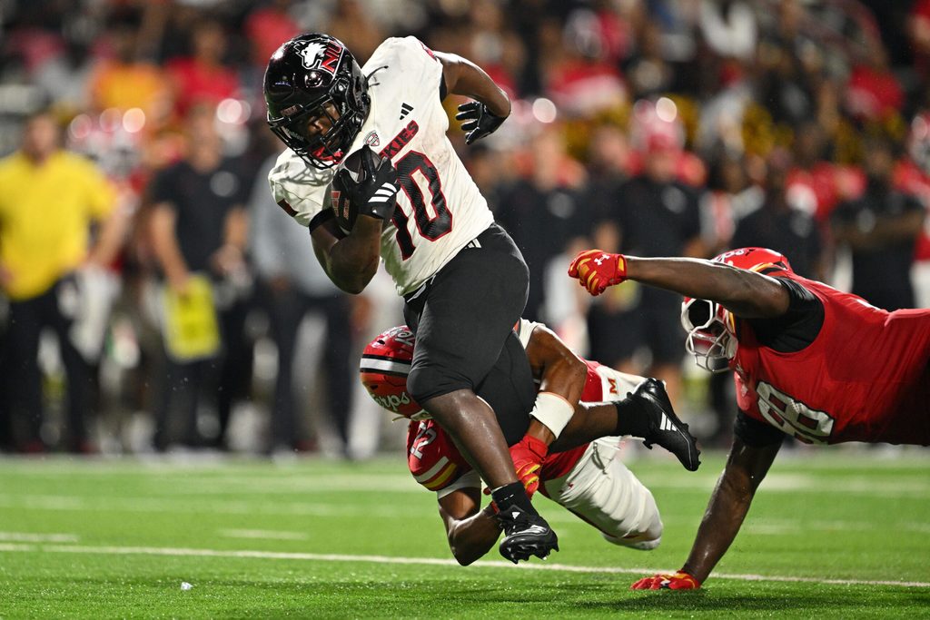 Sep 5, 2025; College Park, Maryland, USA; Northern Illinois Huskies running back Chavon Wright (10) is tripped up by Maryland Terrapins defensive back Jalen Huskey (22) after picking up a first down in the first half at SECU Stadium. Mandatory Credit: Jamie Sabau-Imagn Images