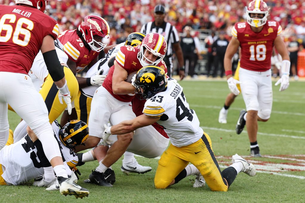 Sep 6, 2025; Ames, Iowa, USA; Iowa Hawkeyes linebacker Karson Sharar (43) tackles Iowa State Cyclones running back Carson Hansen (26) during the second half at Jack Trice Stadium. Mandatory Credit: Reese Strickland-Imagn Images