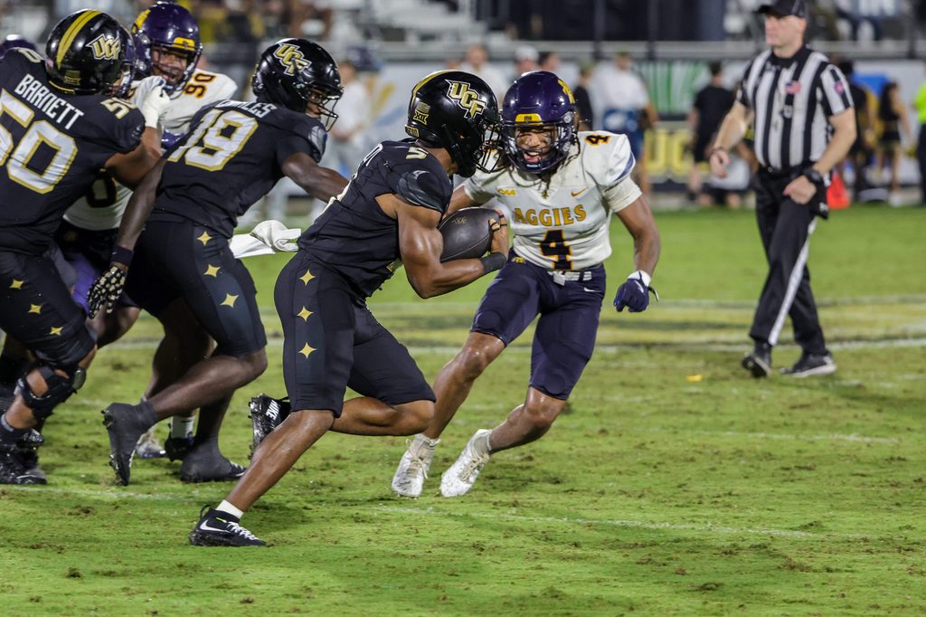 Sep 6, 2025; Orlando, Florida, USA; UCF Knights running back Jaden Nixon (5) carries the ball against North Carolina A&T Aggies cornerback Aaron Harris (4) during the second half at Acrisure Bounce House. Mandatory Credit: Mike Watters-Imagn Images