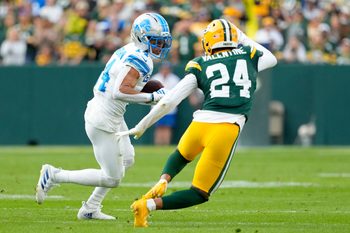 Sep 7, 2025; Green Bay, Wisconsin, USA; Detroit Lions wide receiver Amon-Ra St. Brown (14) runs with the ball after a catch against Green Bay Packers cornerback Carrington Valentine (24) during the fourth quarter at Lambeau Field. Mandatory Credit: Jeff Hanisch-Imagn Images