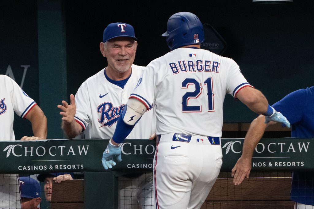 Sep 10, 2025; Arlington, Texas, USA; Texas Rangers first baseman Jake Burger (21) celebrates his two-run home run with manager Bruce Bochy (15) against the Milwaukee Brewers during the fifth inning at Globe Life Field. Mandatory Credit: Jim Cowsert-Imagn Images