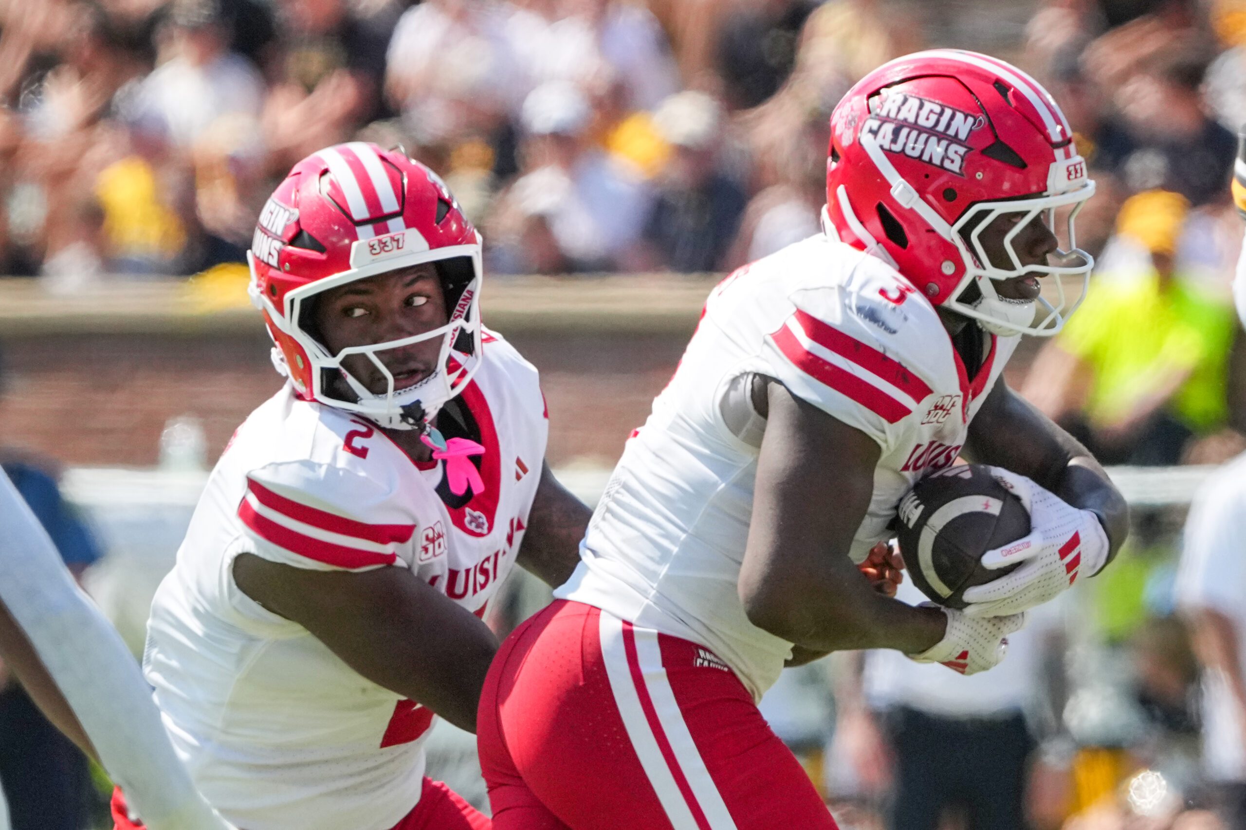 Sep 13, 2025; Columbia, Missouri, USA; Louisiana-Lafayette Ragin Cajuns quarterback Lunch Winfield (2) hands off to running back Zylan Perry (3) against the Missouri Tigers during the first half of the game at Faurot Field at Memorial Stadium. Mandatory Credit: Denny Medley-Imagn Images