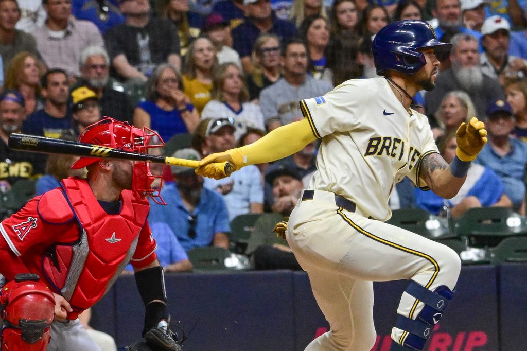 Sep 17, 2025; Milwaukee, Wisconsin, USA; Milwaukee Brewers center fielder Blake Perkins (16) drives in two runs with a base hit as Los Angeles Angels catcher Sebastian Rivero (38) watches in the second inning at American Family Field. Mandatory Credit: Benny Sieu-Imagn Images