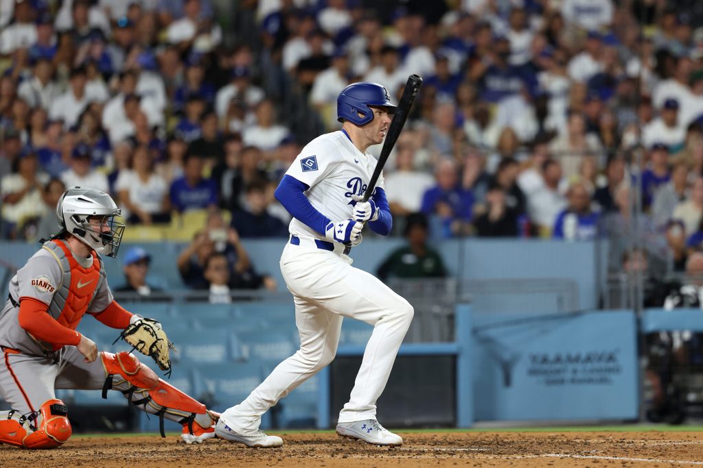 Sep 18, 2025; Los Angeles, California, USA; Los Angeles Dodgers first baseman Freddie Freeman (5) hits an RBI single during the sixth inning against the San Francisco Giants at Dodger Stadium. Mandatory Credit: Kiyoshi Mio-Imagn Images