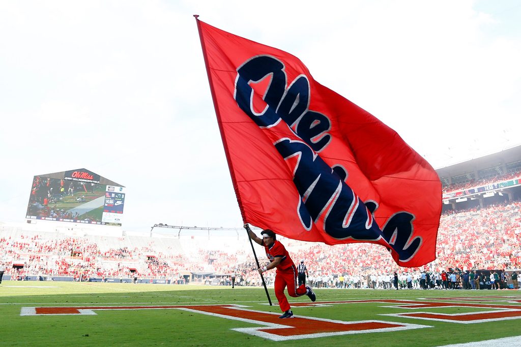 Sep 20, 2025; Oxford, Mississippi, USA; Mississippi Rebels cheerleader run an Ole Miss flag through the end zone after a touchdown during the fourth quarter against the Tulane Green Wave at Vaught-Hemingway Stadium. Mandatory Credit: Petre Thomas-Imagn Images