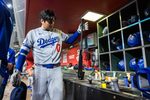 Sep 23, 2025; Phoenix, Arizona, USA; Los Angeles Dodgers designated hitter Shohei Ohtani grabs his bat in the eighth inning against the Arizona Diamondbacks at Chase Field. Mandatory Credit: Mark J. Rebilas-Imagn Images