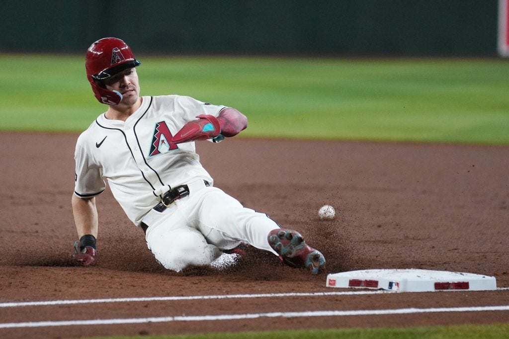Arizona Diamondbacks base runner Corbin Carroll (7) slides back in safely to first base against the Los Angeles Dodgers at Chase Field in Phoenix, on Sept. 24, 2025.