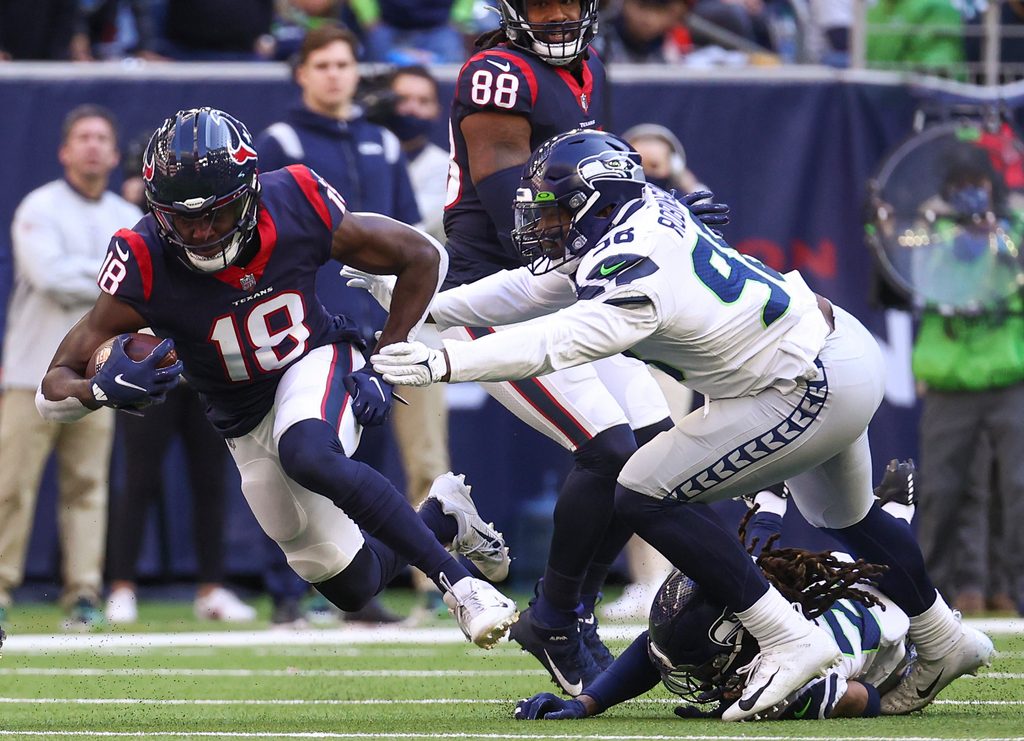Dec 12, 2021; Houston, Texas, USA; Houston Texans wide receiver Chris Conley (18) makes a reception during the fourth quarter as Seattle Seahawks outside linebacker Alton Robinson (98) defends during the fourth quarter at NRG Stadium. Mandatory Credit: Troy Taormina-Imagn Images