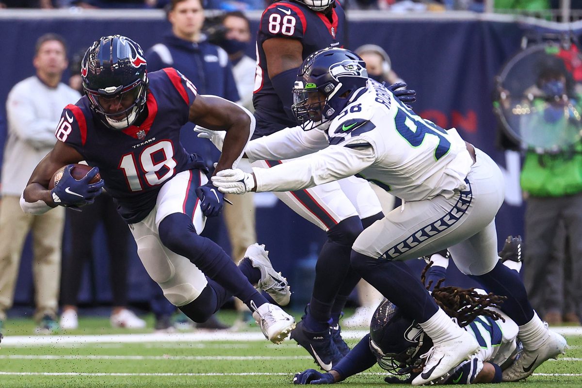 Dec 12, 2021; Houston, Texas, USA; Houston Texans wide receiver Chris Conley (18) makes a reception during the fourth quarter as Seattle Seahawks outside linebacker Alton Robinson (98) defends during the fourth quarter at NRG Stadium. Mandatory Credit: Troy Taormina-Imagn Images