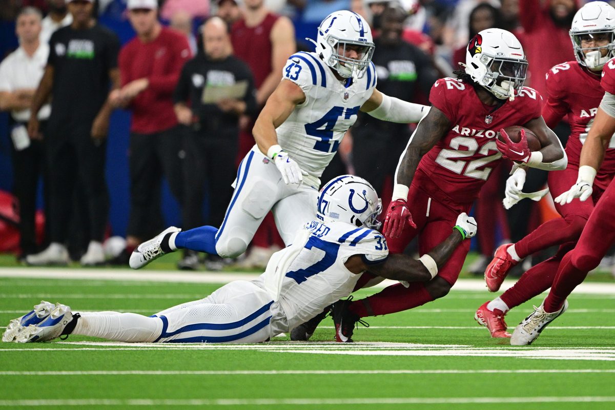Aug 17, 2024; Indianapolis, Indiana, USA; Arizona Cardinals running back Michael Carter (22) is tackled by Indianapolis Colts cornerback Ameer Speed (37) during the second half at Lucas Oil Stadium. Mandatory Credit: Marc Lebryk-Imagn Images