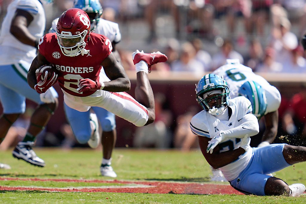 Oklahoma Sooners running back Jovantae Barnes (2) is tripped up by Tulane Green Wave safety Kevin Adams III (23) during a college football game between the University of Oklahoma Sooners (OU) and the Tulane Green Wave at Gaylord Family - Oklahoma Memorial Stadium in Norman, Okla., Saturday, Sept. 14, 2024.