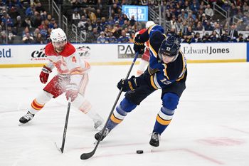 Jan 16, 2025; St. Louis, Missouri, USA; Calgary Flames defenseman Rasmus Andersson (4) defends against St. Louis Blues right wing Alexey Toropchenko (13) in the second period at Enterprise Center. Mandatory Credit: Joe Puetz-Imagn Images