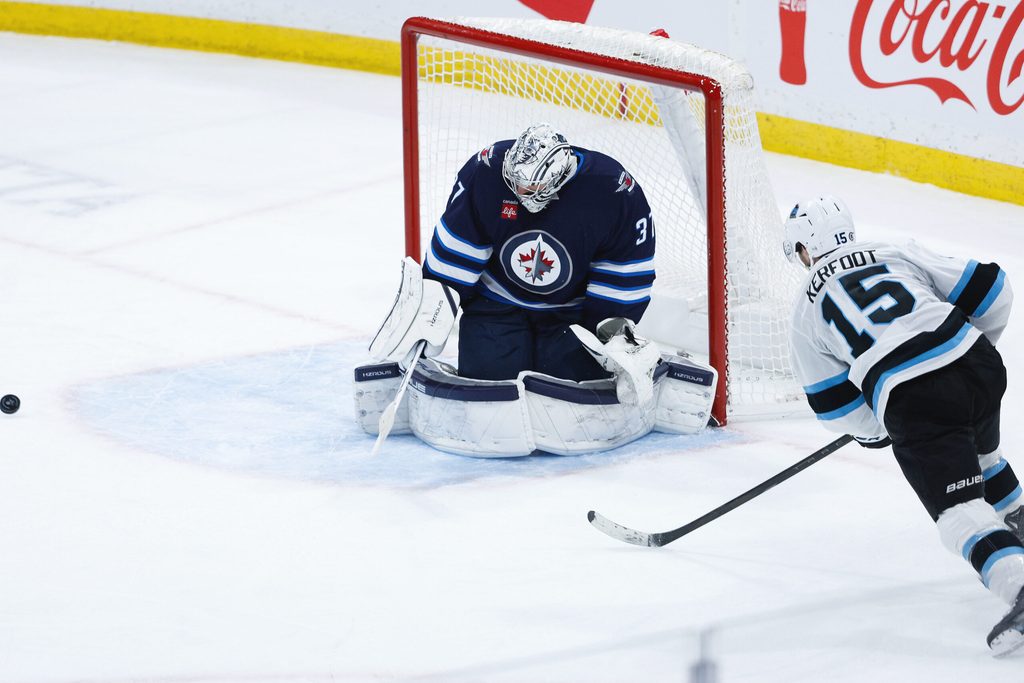 Jan 24, 2025; Winnipeg, Manitoba, CAN; Winnipeg Jets goalie Connor Hellebuyck (37) makes a save on a shot by Utah Hockey Club forward Alexander Kerfoot (15) during the third period at Canada Life Centre. Mandatory Credit: Terrence Lee-Imagn Images