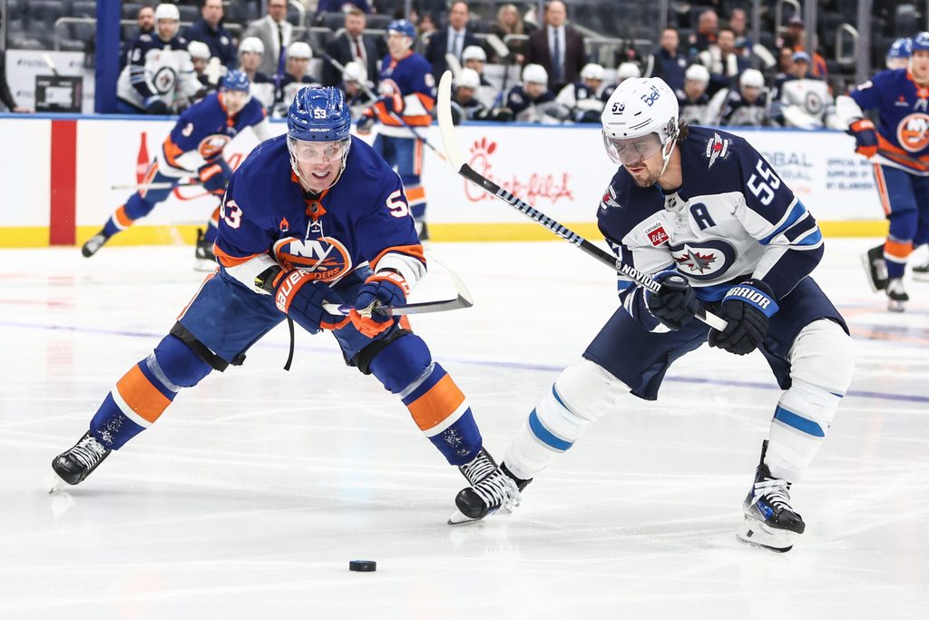 Mar 4, 2025; Elmont, New York, USA; New York Islanders center Casey Cizikas (53) and Winnipeg Jets center Mark Scheifele (55) chase after the puck in the second period at UBS Arena. Mandatory Credit: Wendell Cruz-Imagn Images