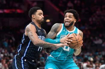 Mar 25, 2025; Charlotte, North Carolina, USA;  Charlotte Hornets forward Miles Bridges (0) looks to pass as he is defended by Orlando Magic guard Gary Harris (14) during the second half at the Spectrum Center. Mandatory Credit: Sam Sharpe-Imagn Images