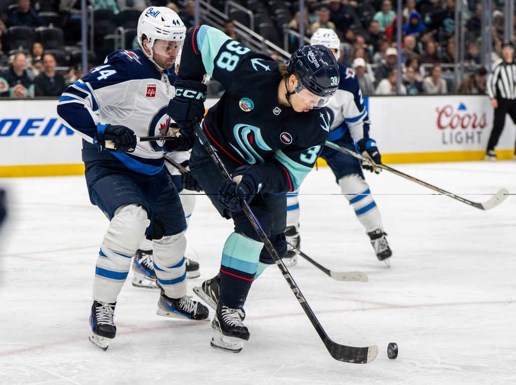 Mar 16, 2025; Seattle, Washington, USA; Seattle Kraken foward Jani Nyman (38) skates against Winnipeg Jets defenseman Josh Morrissey (44) at Climate Pledge Arena. Mandatory Credit: Stephen Brashear-Imagn Images