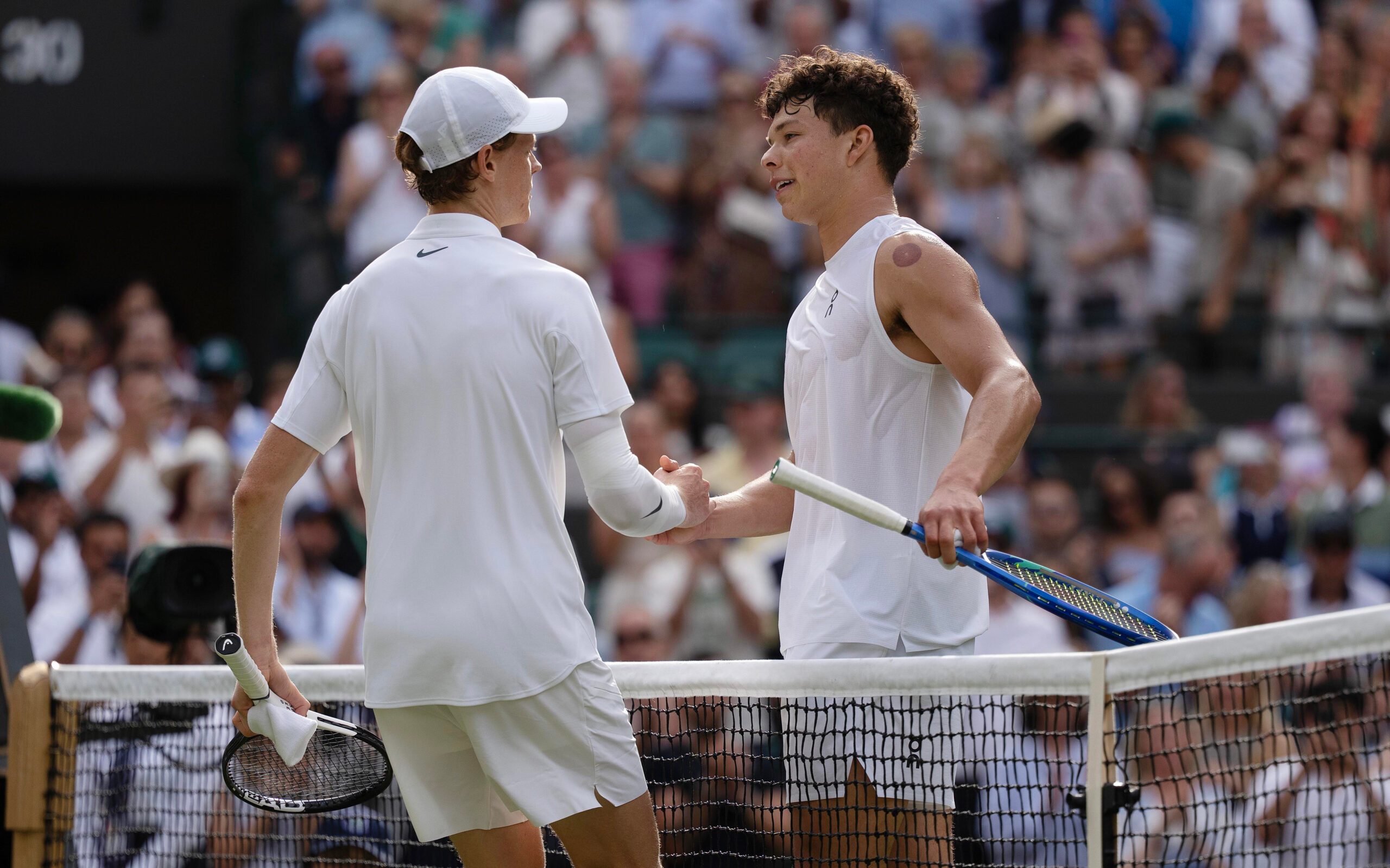 Jul 9, 2025; Wimbledon, United Kingdom; Jannik Sinner of Italy at the net with Ben Shelton of the United States after their match on day 10 at All England Lawn Tennis and Croquet Club. Mandatory Credit: Susan Mullane-Imagn Images