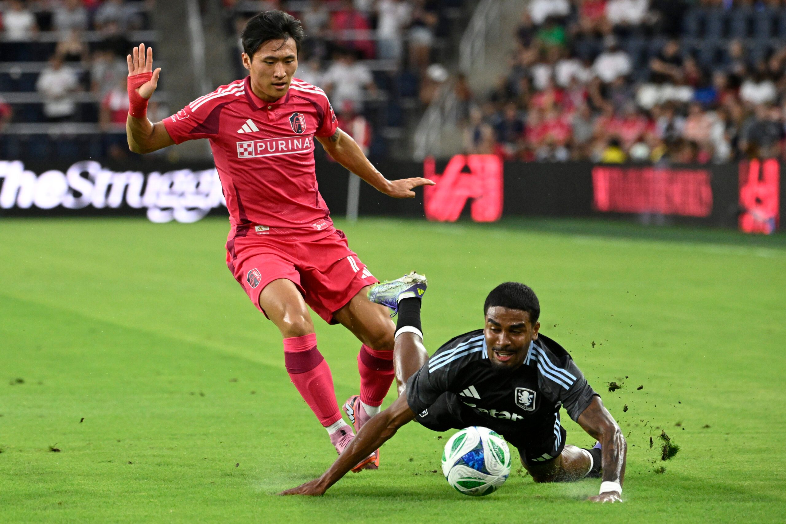 Jul 30, 2025; St. Louis, Missouri, USA; Aston Villa defender Ian Maatsen (22) falls to the pitch after battle St. Louis City forward Jeong Sang-Bin (77) for the ball in the first half at Energizer Park. Mandatory Credit: Joe Puetz-Imagn Images
