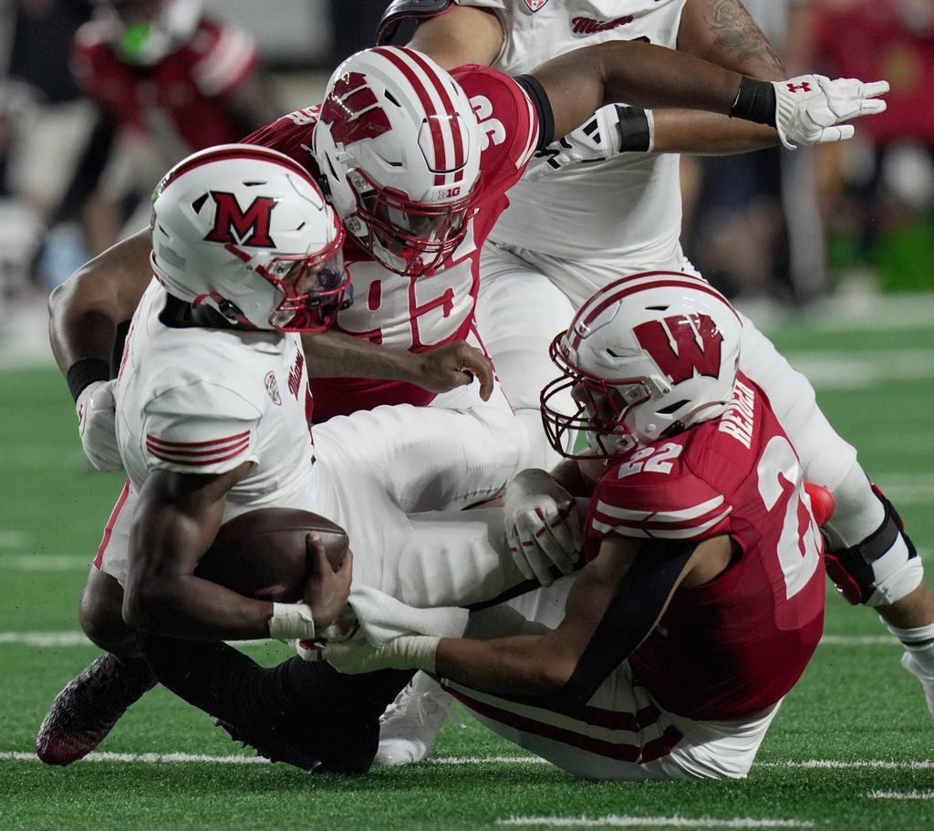 Miami (Ohio) quarterback Dequan Finn (1) is sacked by Wisconsin defensive lineman Brandon Lane (95) and linebacker Mason Reiger (22) during the second quarter of their game Thursday, August 28, 2025 at Camp Randall Stadium in Madison, Wisconsin.