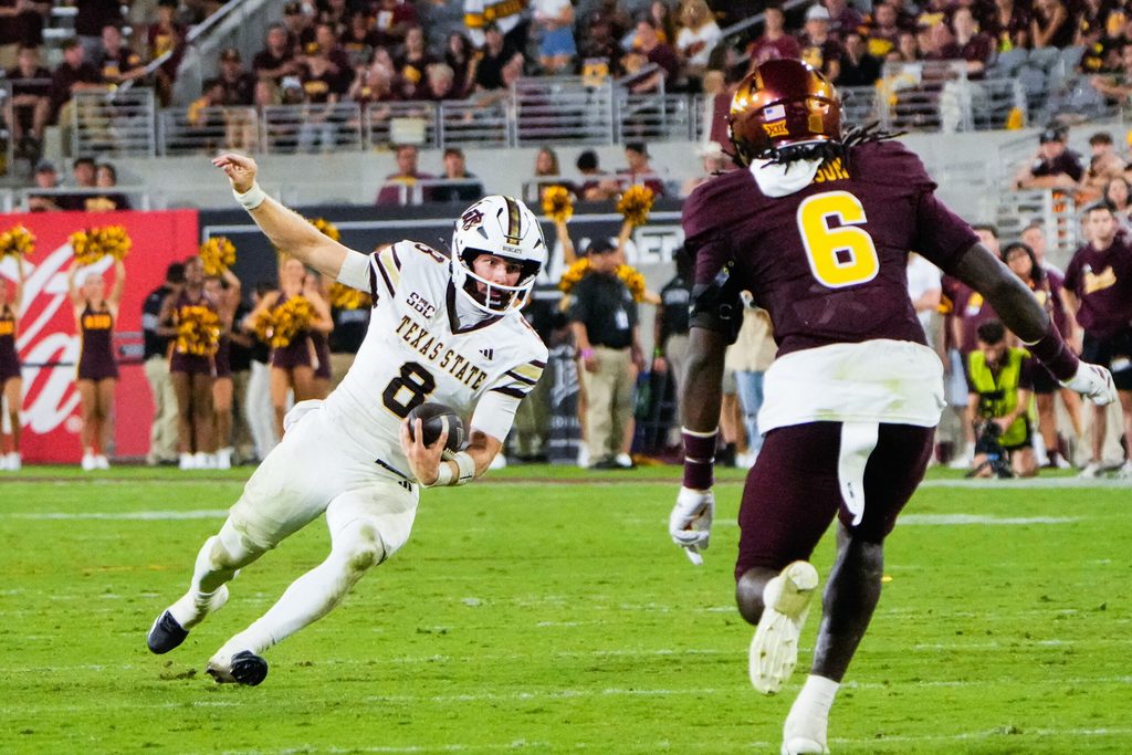 Sep 13, 2025; Tempe, Arizona, USA; Texas State Bobcats quarterback Brad Jackson (8) attempts to avoid a tackle by Arizona State Sun Devils safety Adrian Wilson (6) at Mountain America Stadium. Mandatory Credit: Arianna Grainey-Imagn Images