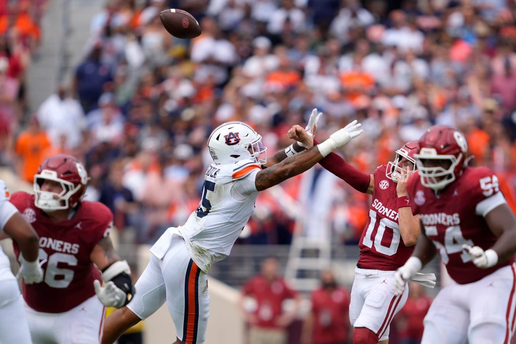 Oklahoma Sooners quarterback John Mateer (10) is hit by Auburn Tigers defensive end Keldric Faulk (15) as he throws in the first quarter of a college football game between the University of Oklahoma Sooners (OU) and the Auburn Tigers at Gaylord Family Ð Oklahoma Memorial Stadium in Norman, Okla., Saturday,Sept. 20, 2025. Oklahoma won 24-17.