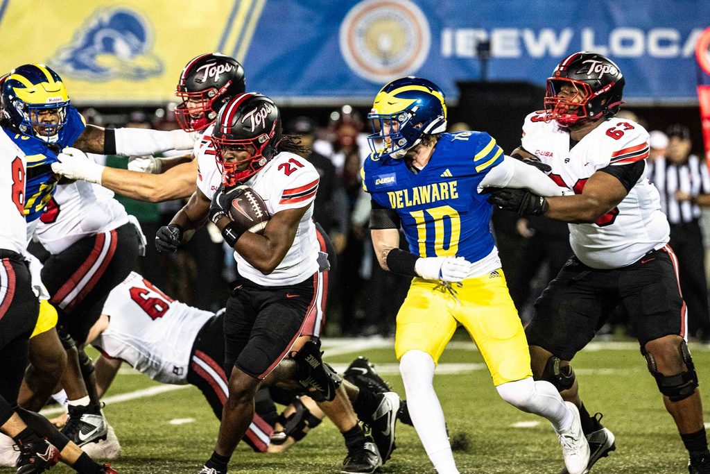 Western Kentucky running back Marvis Parrish (21) runs the ball, with offensive lineman Quincy Jenkins (63) providing cover, against Delaware Blue Hens linebacker Blake Matthews (10) during Delaware's first home CUSA football game, which was nationally televised, at Delaware Stadium in Newark on Oct. 3, 2025. Western Kentucky won 27-24.