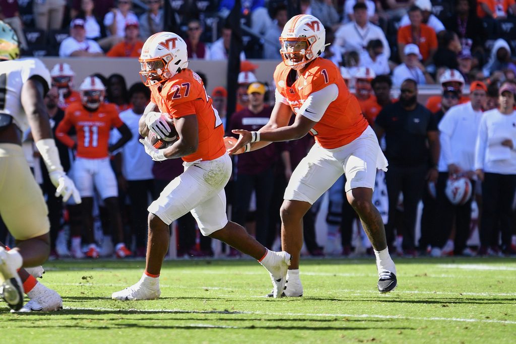 Oct 4, 2025; Blacksburg, Virginia, USA; Virginia Tech Hokies quarterback Kyron Drones (1) hands the ball to running back Marcellous Hawkins (27) against the Wake Forest Demon Deacons during the third quarter at Lane Stadium. Mandatory Credit: Brian Bishop-Imagn Images