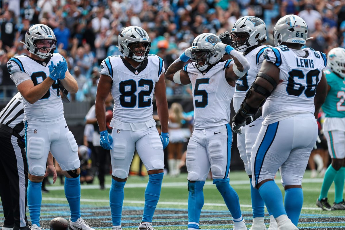Oct 5, 2025; Charlotte, North Carolina, USA; Carolina Panthers running back Rico Dowdle (5) reacts after scoring a touchdown with Carolina Panthers tight end Tommy Tremble (82) and Carolina Panthers tight end Mitchell Evans (84) during the fourth quarter against the Miami Dolphins at Bank of America Stadium. Mandatory Credit: Cory Knowlton-Imagn Images