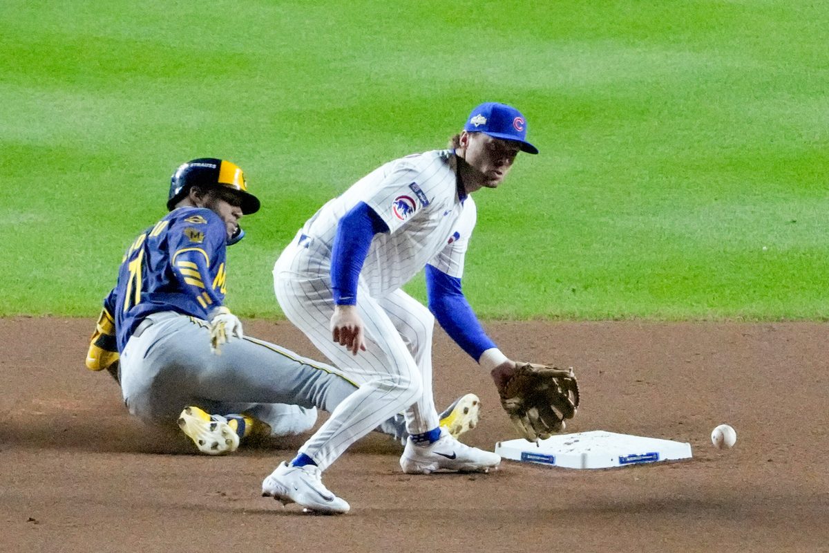 Oct 8, 2025; Chicago, Illinois, USA; Milwaukee Brewers center fielder Jackson Chourio (11) slides into second base safely with a double as Chicago Cubs second baseman Nico Hoerner (2) fields the throw in the eighth inning during game three of the NLDS round for the 2025 MLB playoffs at Wrigley Field. Mandatory Credit: David Banks-Imagn Images