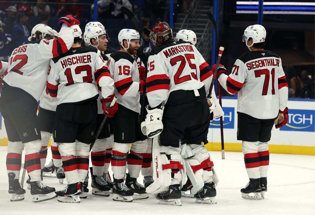 Oct 11, 2025; Tampa, Florida, USA; New Jersey Devils goaltender Jacob Markstrom (25), right wing Connor Brown (16), defenseman Jonas Siegenthaler (71) and teammates celebrate after they beat the Tampa Bay Lightning at Benchmark International Arena. Mandatory Credit: Kim Klement Neitzel-Imagn Images