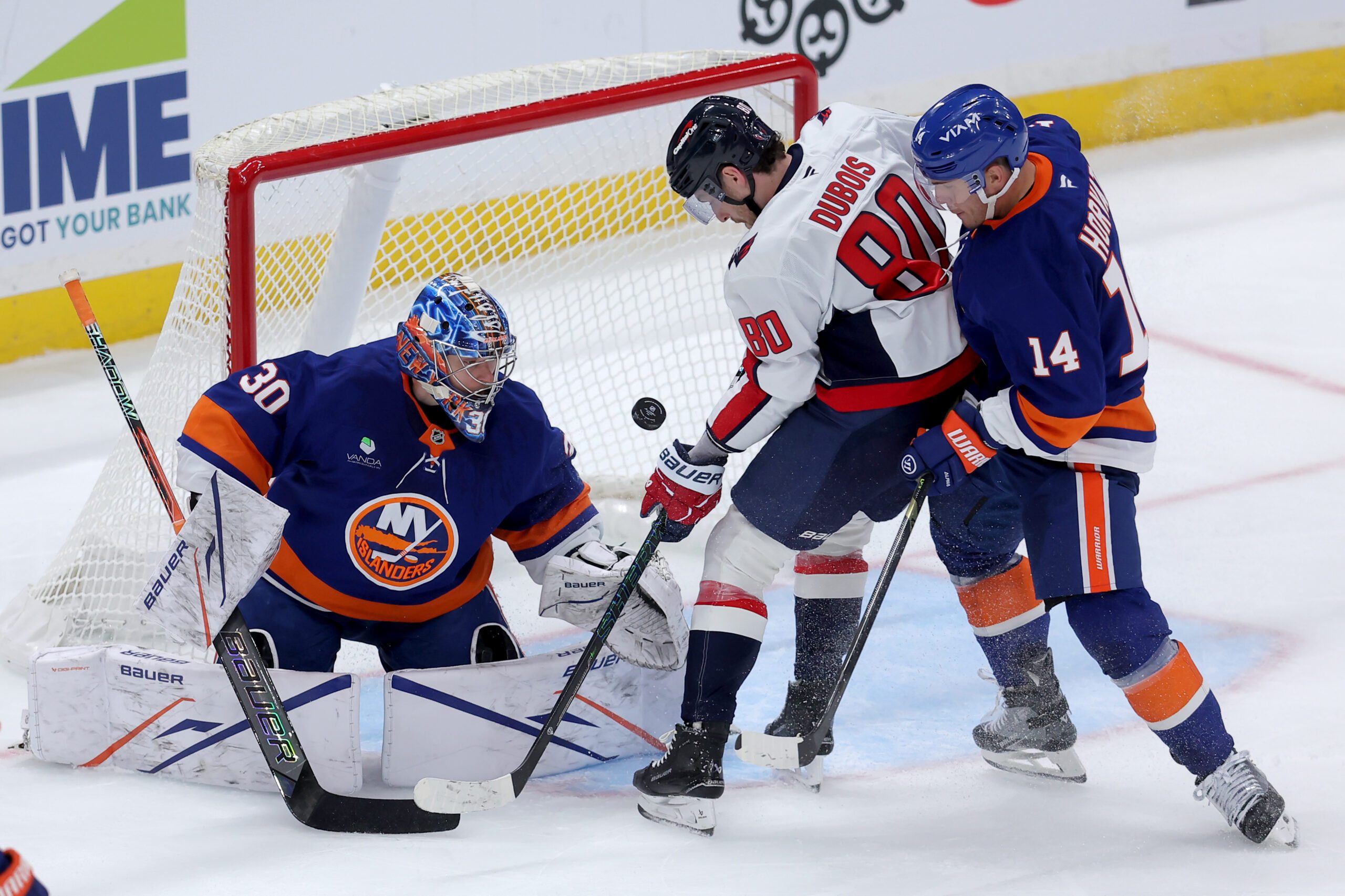 Oct 11, 2025; Elmont, New York, USA; Washington Capitals left wing Pierre-Luc Dubois (80) plays the puck against New York Islanders goaltender Ilya Sorokin (30) and center Bo Horvat (14) during the third period at UBS Arena. Mandatory Credit: Brad Penner-Imagn Images