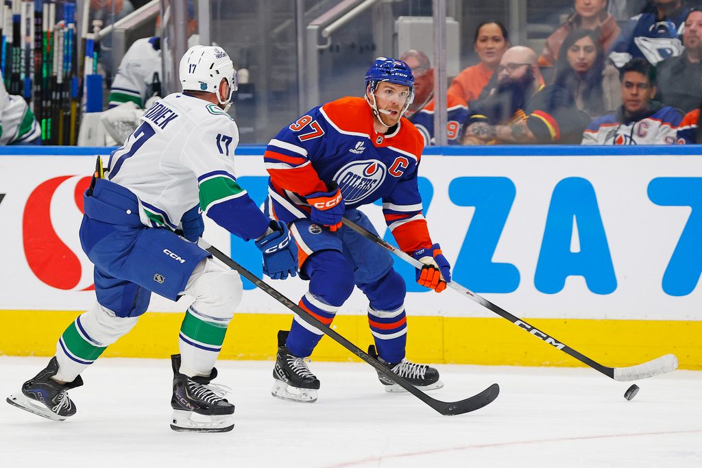 Oct 11, 2025; Edmonton, Alberta, CAN; Edmonton Oilers forward Connor McDavid (97) looks to make a pass in front of Vancouver Canucks defensemen Filip Hornek (17) during the third period at Rogers Place. Mandatory Credit: Perry Nelson-Imagn Images