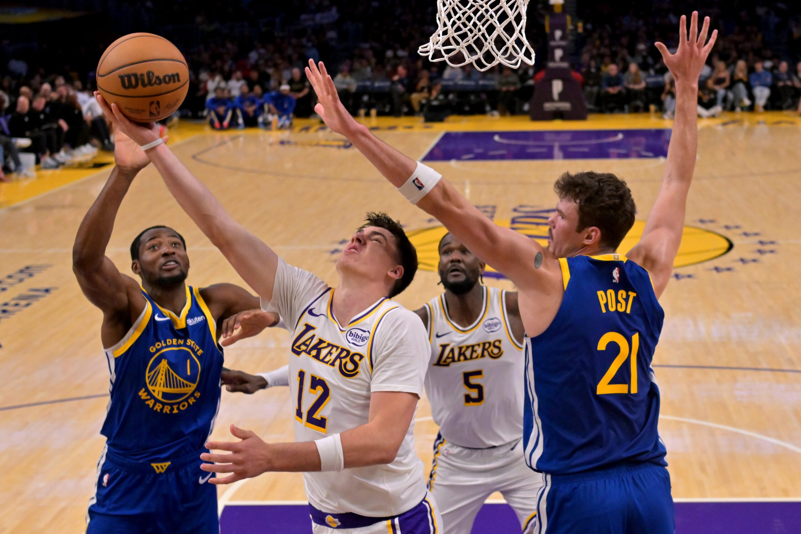 Oct 12, 2025; Los Angeles, California, USA;  Los Angeles Lakers forward Jake Laravia (12) is defended by Golden State Warriors center Quinten Post (21) as he takes a shot during the second half at Crypto.com Arena. Mandatory Credit: Jayne Kamin-Oncea-Imagn Images