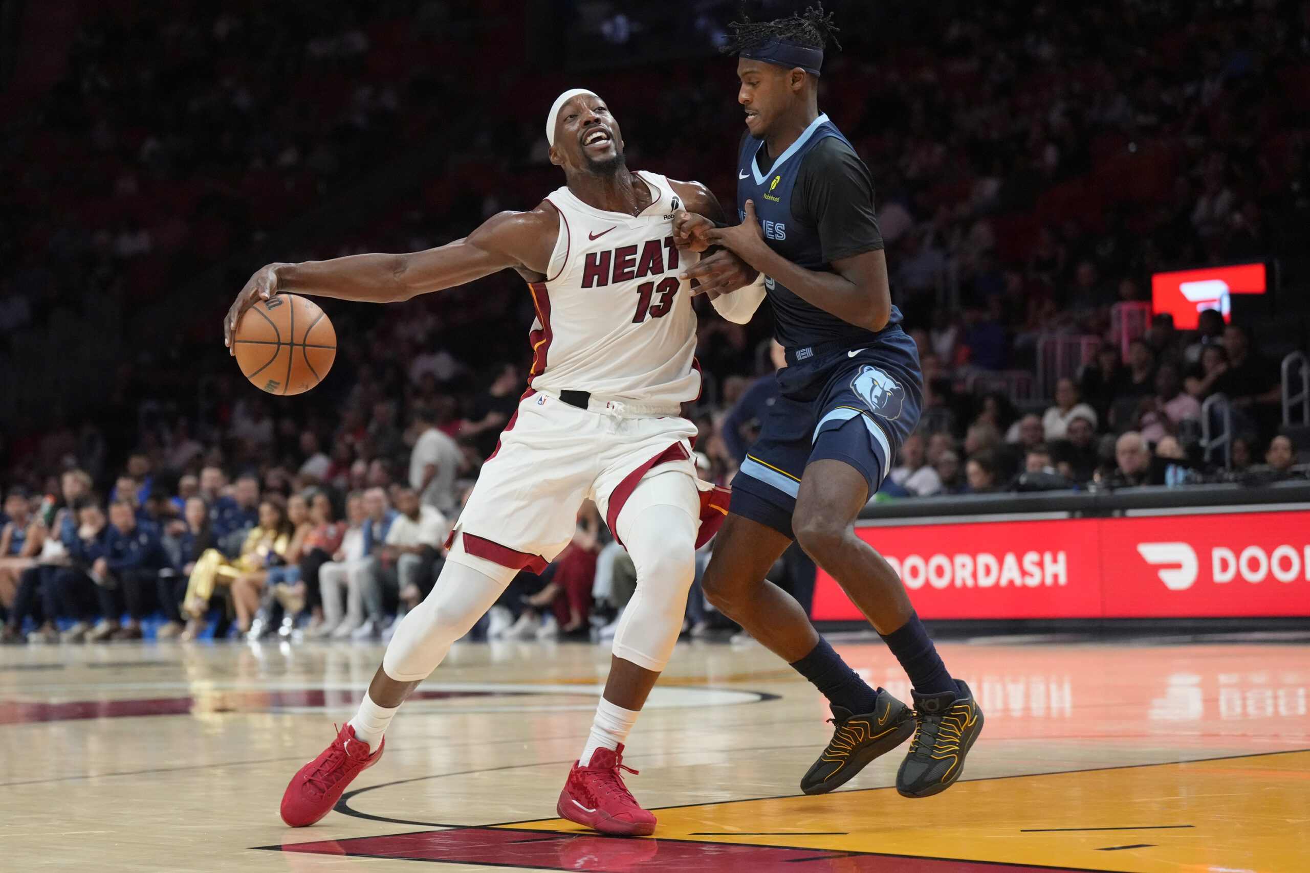 Oct 17, 2025; Miami, Florida, USA; Memphis Grizzlies forward Olivier-Maxence Prosper (18) collides with Miami Heat center Bam Adebayo (13) during the first half at Kaseya Center. Mandatory Credit: Jim Rassol-Imagn Images