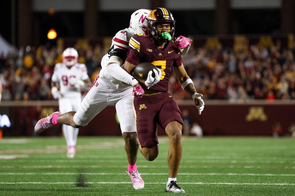 Oct 17, 2025; Minneapolis, Minnesota, USA; Minnesota Golden Gophers wide receiver Jalen Smith (8) runs after a catch as Nebraska Cornhuskers linebacker Javin Wright (0) defends during the second half at Huntington Bank Stadium. Mandatory Credit: Matt Krohn-Imagn Images