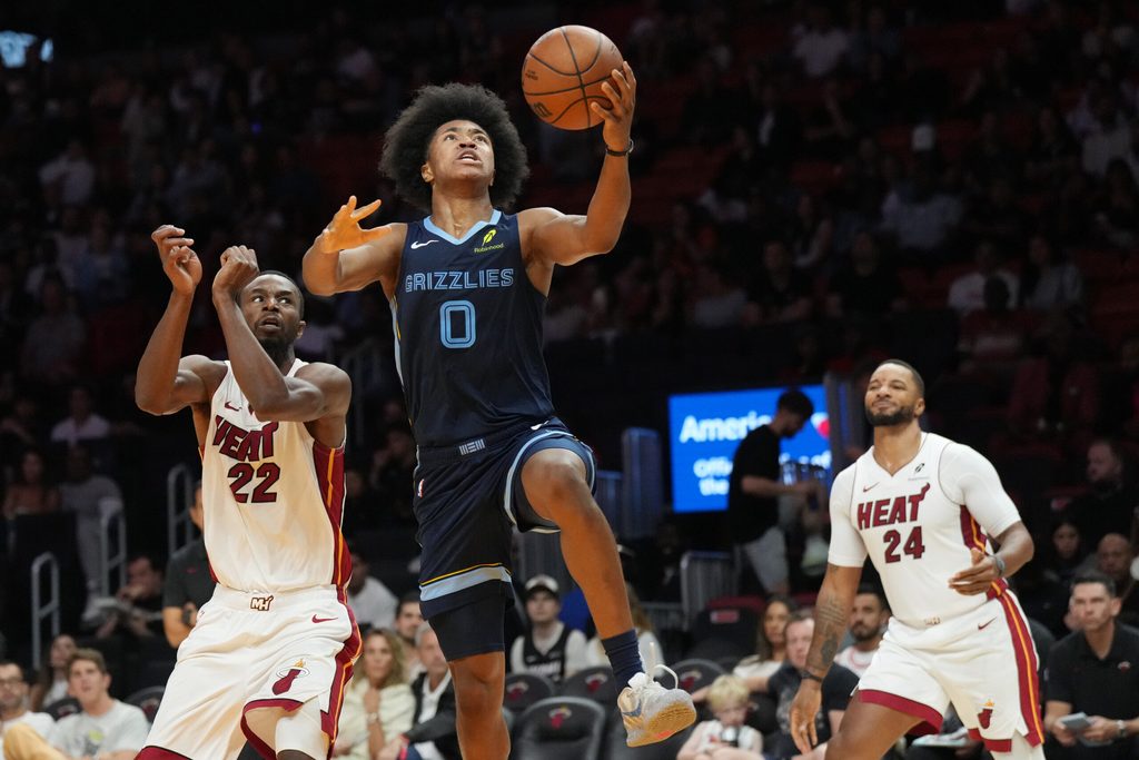 Oct 17, 2025; Miami, Florida, USA;  Memphis Grizzlies guard Jaylen Wells (0) drives to the basket as Miami Heat forward Andrew Wiggins (22) and guard Norman Powell (24) look on during the second half at Kaseya Center. Mandatory Credit: Jim Rassol-Imagn Images