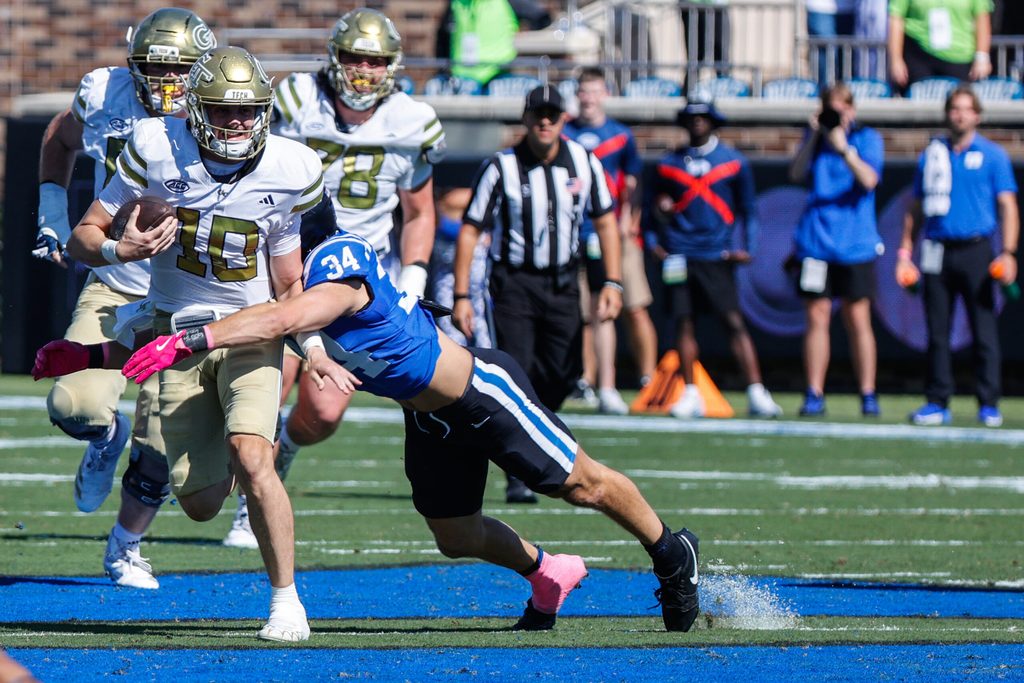 Oct 18, 2025; Durham, North Carolina, USA; Duke Blue Devils linebacker Luke Mergott (34) tackles Georgia Tech Yellow Jackets quarterback Haynes King (10) during the first half of the game at Wallace Wade Stadium. Mandatory Credit: Jaylynn Nash-Imagn Images