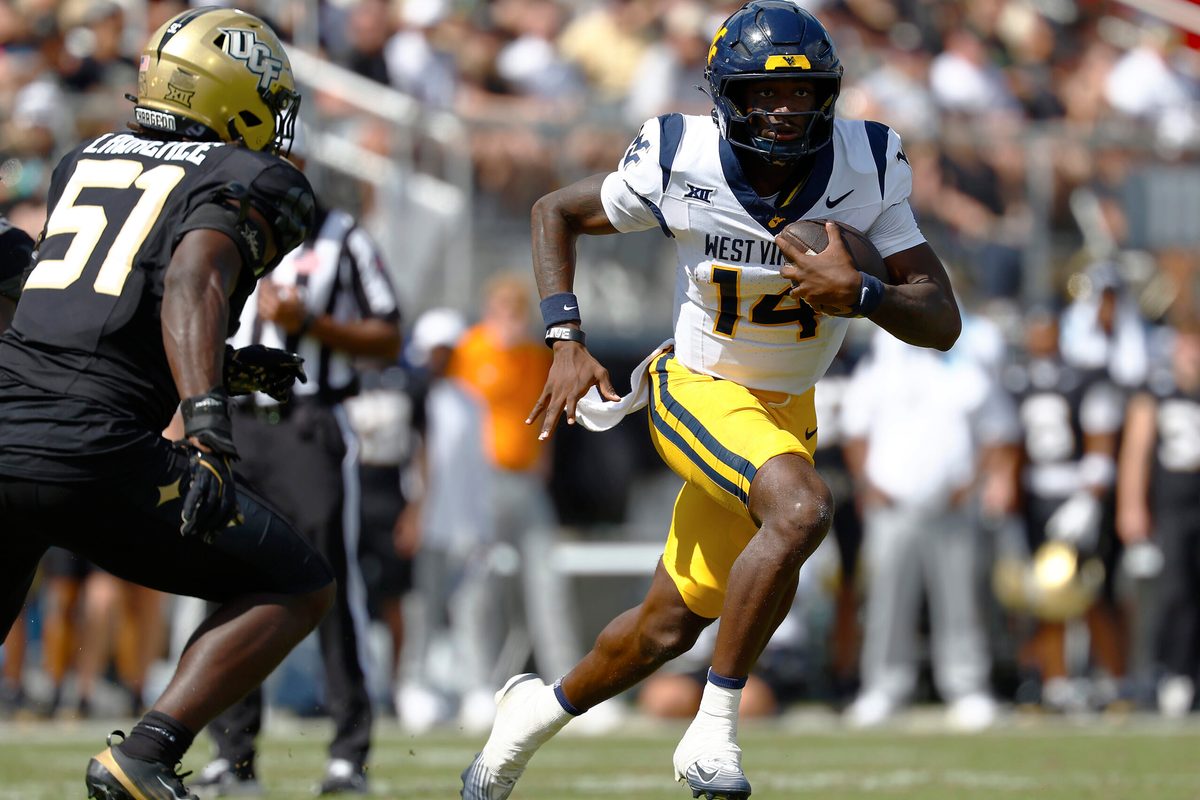 Oct 18, 2025; Orlando, Florida, USA; West Virginia Mountaineers quarterback Khalil Wilkins (14) runs the ball for a touchdown in the first half against the Central Florida Knights at Acrisure Bounce House. Mandatory Credit: Russell Lansford-Imagn Images