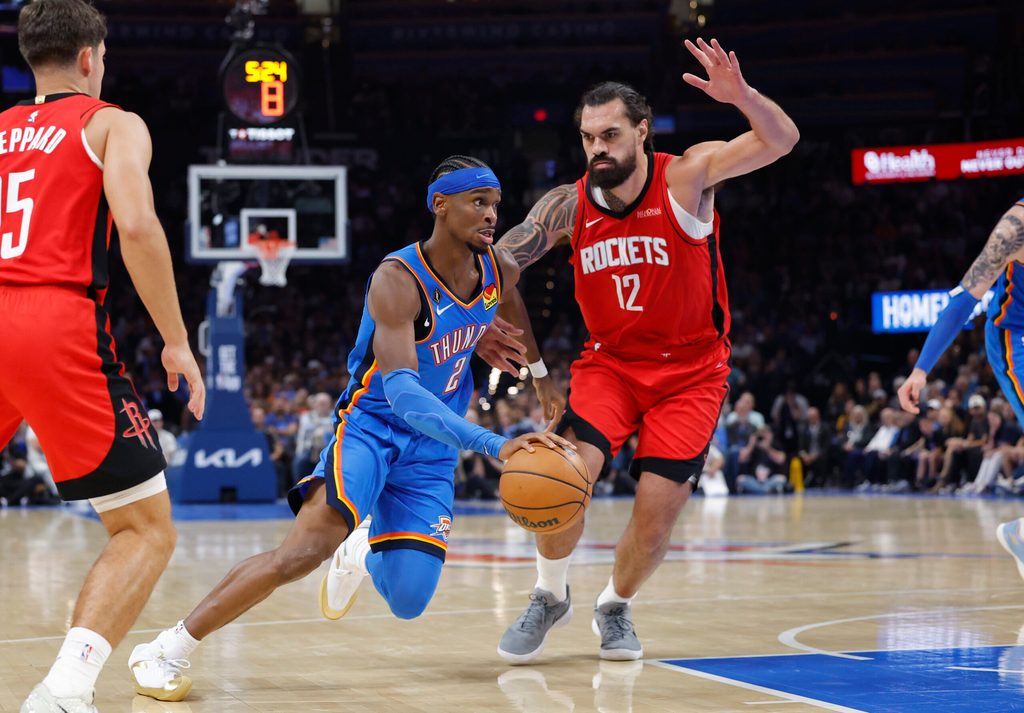 Oct 21, 2025; Oklahoma City, Oklahoma, USA; Oklahoma City Thunder guard Shai Gilgeous-Alexander (2) drives to the basket beside Houston Rockets center Steven Adams (12) during the first half at Paycom Center. Mandatory Credit: Alonzo Adams-Imagn Images