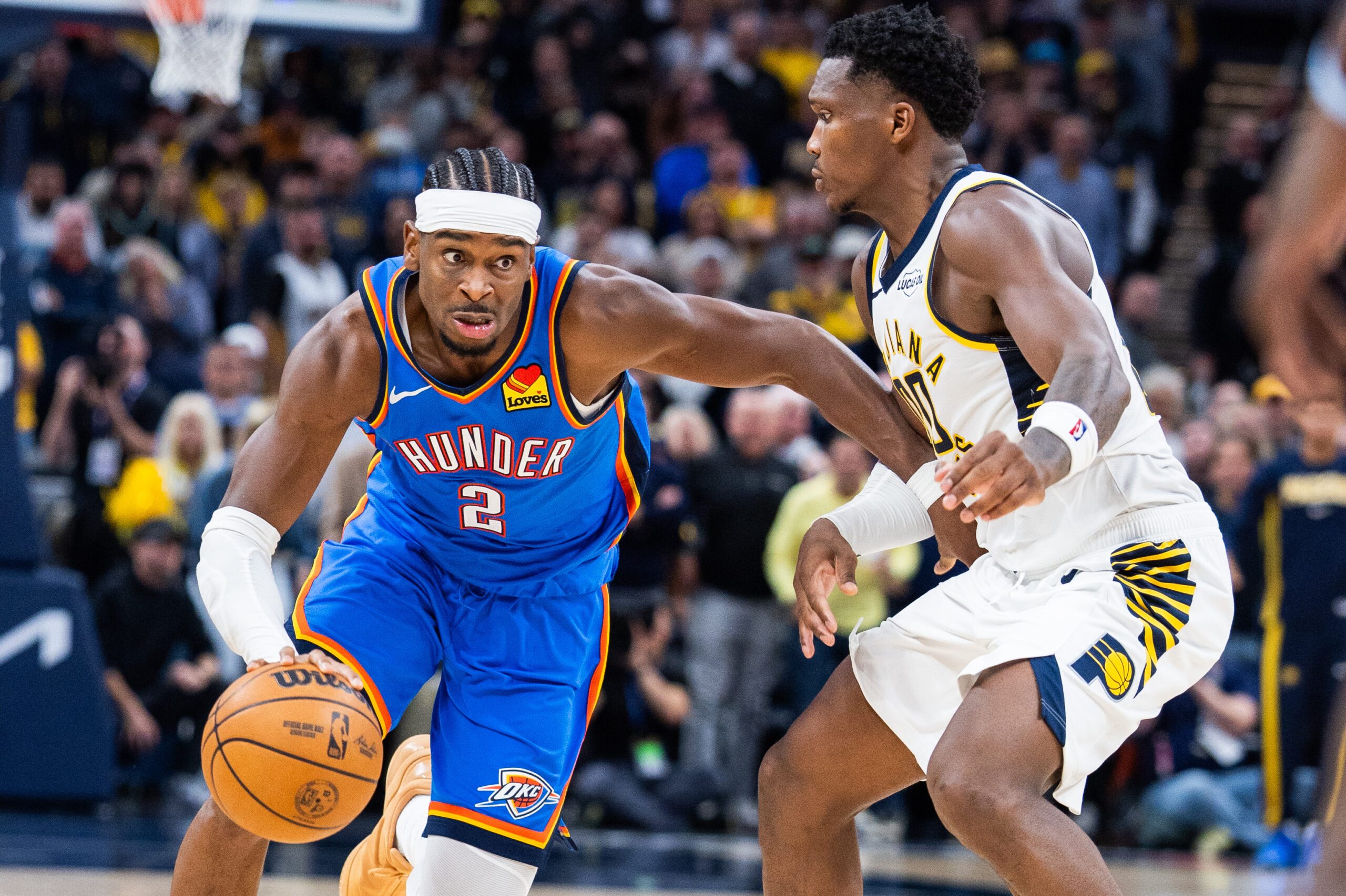 Oct 23, 2025; Indianapolis, Indiana, USA;  Oklahoma City Thunder guard Shai Gilgeous-Alexander (2) dribbles the ball while Indiana Pacers guard Bennedict Mathurin (00) defends in the second half at Gainbridge Fieldhouse. Mandatory Credit: Trevor Ruszkowski-Imagn Images
