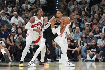 Oct 27, 2025; San Antonio, Texas, USA;  San Antonio Spurs forward/center Victor Wembanyama (1) looks to pass in front of Toronto Raptors forward Collin Murray-Boyles (12) in the second half at Frost Bank Center. Mandatory Credit: Daniel Dunn-Imagn Images