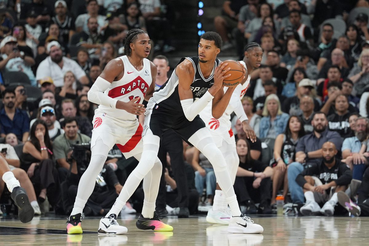 Oct 27, 2025; San Antonio, Texas, USA; San Antonio Spurs forward/center Victor Wembanyama (1) looks to pass in front of Toronto Raptors forward Collin Murray-Boyles (12) in the second half at Frost Bank Center. Mandatory Credit: Daniel Dunn-Imagn Images