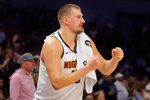 Oct 27, 2025; Minneapolis, Minnesota, USA; Denver Nuggets center Nikola Jokic (15) cheers on his team as he rests against the Minnesota Timberwolves in the fourth quarter at Target Center. Mandatory Credit: Bruce Kluckhohn-Imagn Images