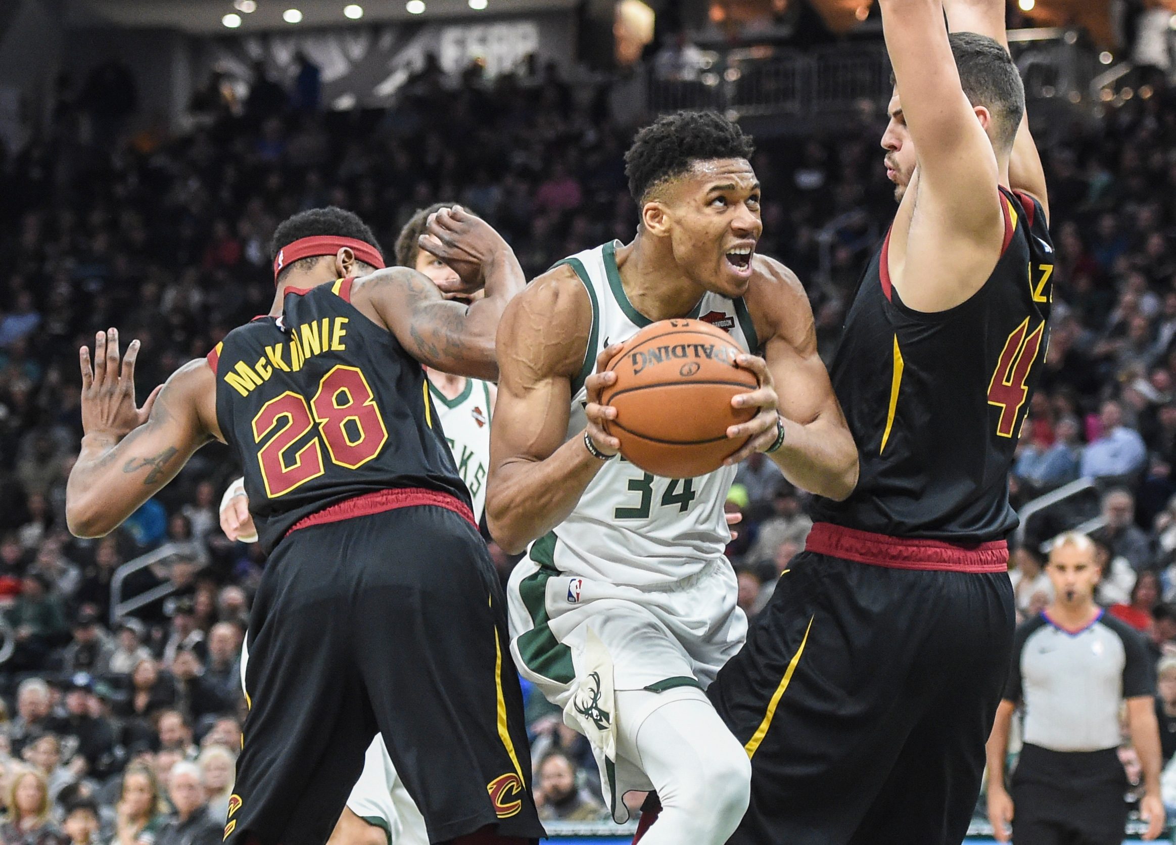 Dec 14, 2019; Milwaukee, WI, USA;  Milwaukee Bucks forward Giannis Antetokounmpo (34) drives for the basket between Cleveland Cavaliers forward Alfonzo McKinnie (28) and center Ante Zizic (41) in the fourth quarter at Fiserv Forum. Mandatory Credit: Benny Sieu-Imagn Images