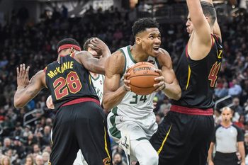 Dec 14, 2019; Milwaukee, WI, USA;  Milwaukee Bucks forward Giannis Antetokounmpo (34) drives for the basket between Cleveland Cavaliers forward Alfonzo McKinnie (28) and center Ante Zizic (41) in the fourth quarter at Fiserv Forum. Mandatory Credit: Benny Sieu-Imagn Images