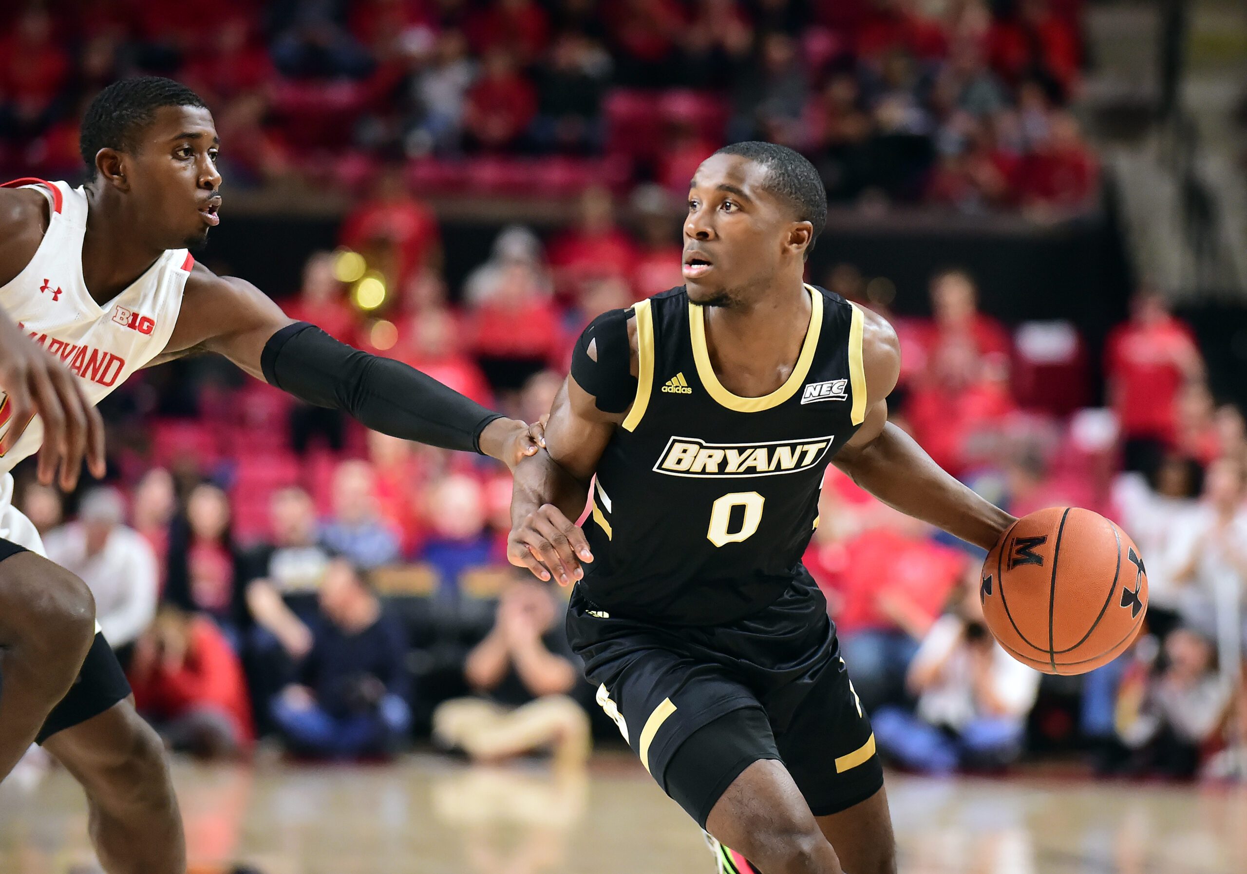 Dec 29, 2019; College Park, Maryland, USA; Bryant Bulldogs guard Ikenna Ndugba (0) dribbles while being defended by Maryland Terrapins guard Darryl Morsell (11) in the first half at XFINITY Center. Mandatory Credit: Evan Habeeb-Imagn Images